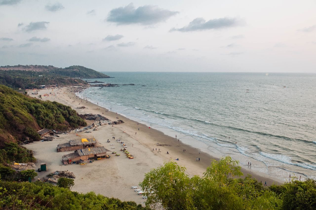 Enjoy the serene aerial view of Chapora Beach, Goa, India, showcasing pristine sands and lush greenery.